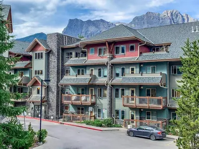 a building with a car parked in front of it at Chic 1BR City Nest Heated Parking and Hot Tub and Pool in Canmore