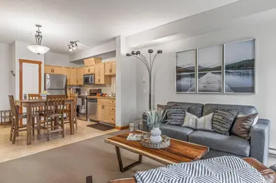a living room with a couch and a table at Chic 1BR City Nest Heated Parking and Hot Tub and Pool in Canmore