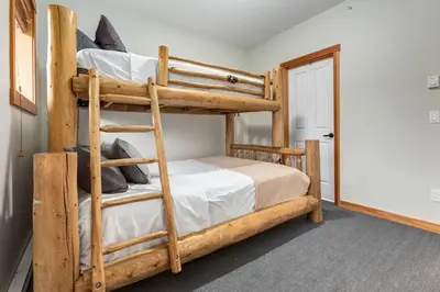 a bedroom with two bunk beds and a doorway at Lovely 2BR Canmore Condo w Heated Pool and Hot Tub in Canmore