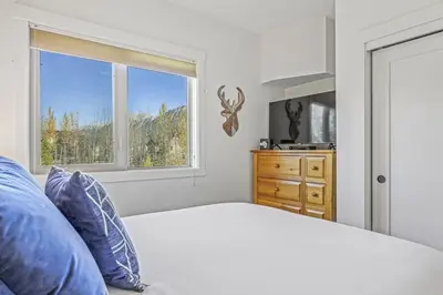 a bedroom with a bed and a window and a dresser at Spacious 2BR Minutes from Downtown w Pool and Hot Tub in Canmore