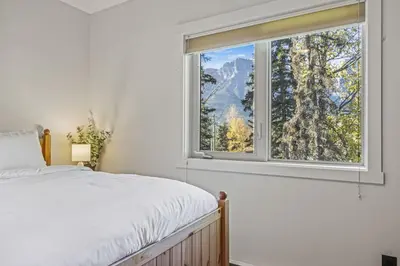a bedroom with a bed and a window at Spacious 2BR Minutes from Downtown w Pool and Hot Tub in Canmore