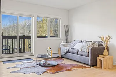 a living room with a couch and a table at Spacious 2BR Minutes from Downtown w Pool and Hot Tub in Canmore