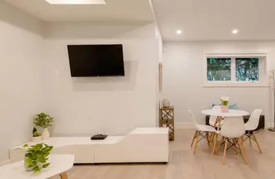 a white living room with a white couch and a table at 2BR Suite Close to Transit - Great for FIFA Vancouver in Burnaby