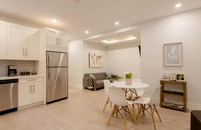 a kitchen and living room with a table and chairs at 2BR Suite Close to Transit - Great for FIFA Vancouver in Burnaby