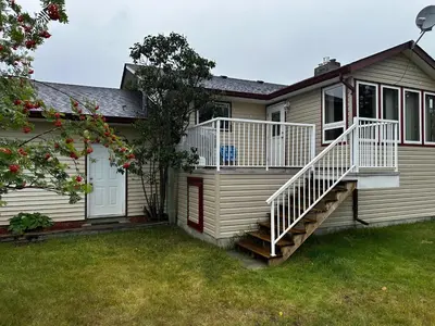 a house with a staircase in front of it at Cozy Farmhouse B&B Retreat in Williams Lake