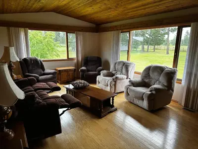 a living room with three chairs and a coffee table at Cozy Farmhouse B&B Retreat in Williams Lake