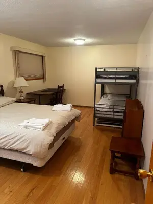a bedroom with two beds and a bunk bed at Cozy Farmhouse B&B Retreat in Williams Lake