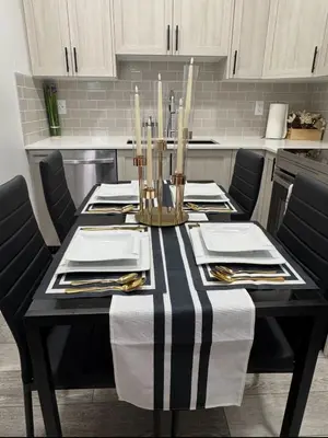 a black and white table in a kitchen with chairs at Luxury Haven by Kc & Flo in Calgary