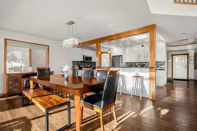 a kitchen and dining room with a wooden table and chairs at Bright & Spacious 5-BR & Ravine Views in Edgemont in Calgary
