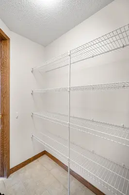 a walk in closet with white shelves at Bright & Spacious 5-BR & Ravine Views in Edgemont in Calgary