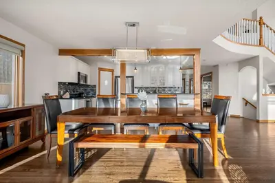 a dining room with a wooden table and chairs at Bright & Spacious 5-BR & Ravine Views in Edgemont in Calgary