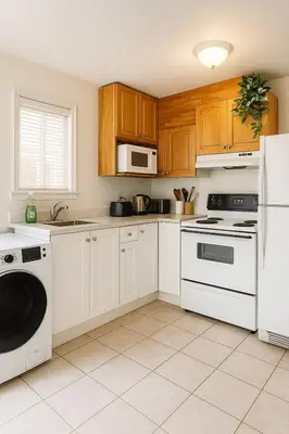 a kitchen with white appliances and wooden cabinets at Sweet 2-bedrooms house in Vancouver in Vancouver
