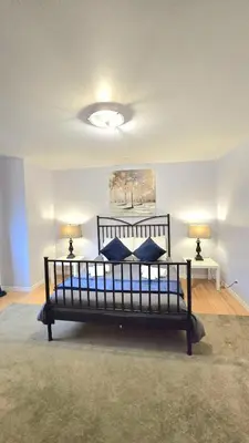 a bed in a room with two lamps in a room at Spacious & Cozy House Near Lonsdale, Peaceful North Vancouver Stay in North Vancouver