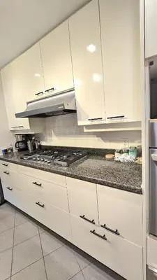 a kitchen with white cabinets and a stove at Spacious & Cozy House Near Lonsdale, Peaceful North Vancouver Stay in North Vancouver