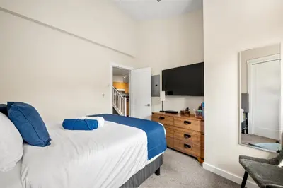 a bedroom with a large bed and a television at Sleeps 8 Loft with Pool Hot Tub Near Banff in Canmore