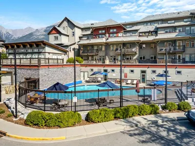 a hotel with a pool in front of a building at Sleeps 8 Loft with Pool Hot Tub Near Banff in Canmore