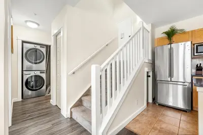 a kitchen with a staircase and a refrigerator at Sleeps 8 Loft with Pool Hot Tub Near Banff in Canmore
