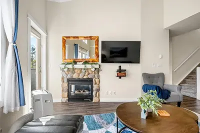 a living room with a fireplace and a mirror at Sleeps 8 Loft with Pool Hot Tub Near Banff in Canmore