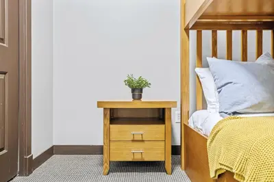 a bed with a night stand with a plant on it at Rockies Getaway 2BR with Patio Hot Tub and Gym in Dead Man's Flats