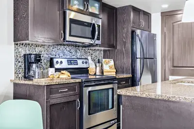 a kitchen with a stove and a microwave at Rockies Getaway 2BR with Patio Hot Tub and Gym in Dead Man's Flats