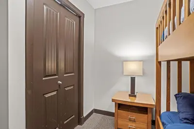 a room with a door and a bed and a lamp at Cozy Oasis 2BR with Hot Tub and Gym 10 Mins to DT in Dead Man's Flats