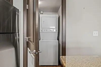 a kitchen with a refrigerator and a washer and dryer at Cozy Oasis 2BR with Hot Tub and Gym 10 Mins to DT in Dead Man's Flats