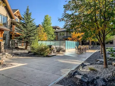 a patio with a table and chairs in a yard at Cozy Oasis 2BR with Hot Tub and Gym 10 Mins to DT in Dead Man's Flats