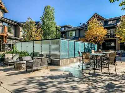 a patio with chairs and a table and a fence at Cozy Oasis 2BR with Hot Tub and Gym 10 Mins to DT in Dead Man's Flats