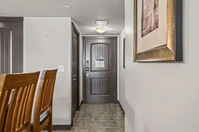 a hallway with a wooden door and a stairway at Cozy Oasis 2BR with Hot Tub and Gym 10 Mins to DT in Dead Man's Flats