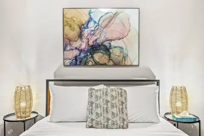 a bedroom with a bed and a painting on the wall at Contemporary 2BR with hot tub and Mountain Views in Dead Man's Flats
