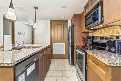 a kitchen with a sink and a stove top oven at Contemporary 2BR with hot tub and Mountain Views in Dead Man's Flats