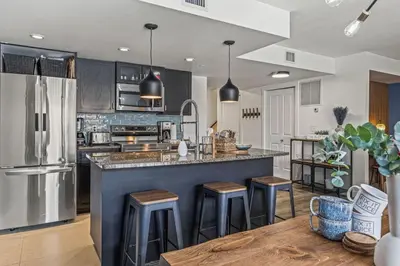 a kitchen with a large island with bar stools at Amazing 3BR Condo With Hot Tub Access and Mtn Views in Dead Man's Flats