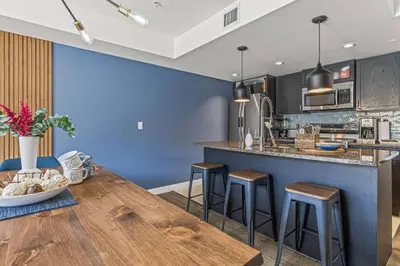 a kitchen with a large wooden table and stools at Amazing 3BR Condo With Hot Tub Access and Mtn Views in Dead Man's Flats