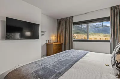 a bedroom with a large bed and a large window at Amazing 3BR Condo With Hot Tub Access and Mtn Views in Dead Man's Flats