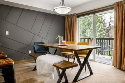 a dining room with a table and chairs and a balcony at Lovely 3BR condo with Hot Tub at the Edge of Canmore in Dead Man's Flats