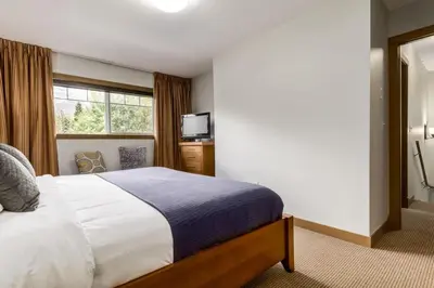 a bedroom with a large bed and a window at Lovely 3BR condo with Hot Tub at the Edge of Canmore in Dead Man's Flats