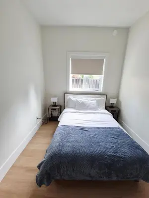 a bedroom with a large bed with a window at Sunny Skies Suites in Surrey