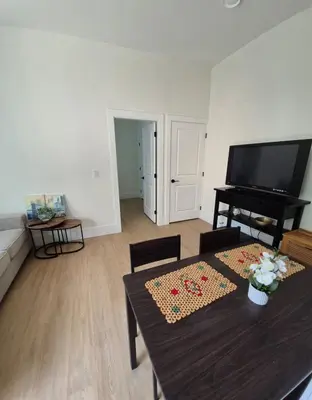 a living room with a table and a piano at Sunny Skies Suites in Surrey
