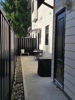 a patio with a black door next to a house at Sunny Skies Suites in Surrey