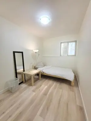 a bedroom with a bed and a table and a mirror at Newly Renovated Cozy Guest House In Joyce-Collingwood in Vancouver