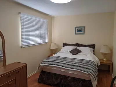 a bedroom with a bed and two lamps and a window at Dragon's End Guesthouse in Massett