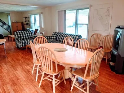 a living room with a wooden table and chairs at Dragon's End Guesthouse in Massett