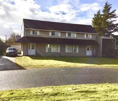 a house with a car parked in front of it at Dragon's End Guesthouse in Massett