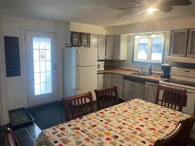 a kitchen with a table and a white refrigerator at Large Farm in Bélanger