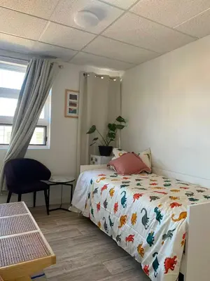 a bedroom with a bed and a chair and a window at ArtHaus Downtown Jim Robb Unit 3BR 3BA in Whitehorse