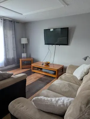 a living room with two couches and a flat screen tv at 347 Des Meurons Street Unit A and Unit B in Bélanger