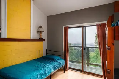 a bedroom with a bed and a large window at The Mushroom Manor B&B and Cedar Sauna in Salt Spring Island