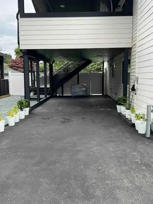 a garage with a porch with potted plants at Ricky's Apartment in Delta