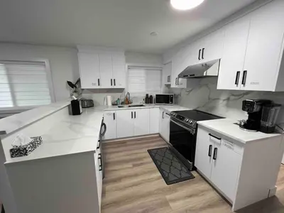 a kitchen with white counters and white cabinets at Ricky's Apartment in Delta