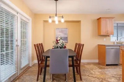 a kitchen with a dining room table and chairs at Cozy 3BR Family Home near City Centre & SkyTrain in Coquitlam